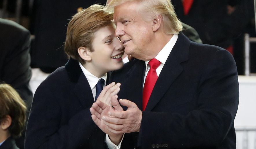 President Donald Trump, right, smiles with his son Barron as they view the 58th Presidential Inauguration parade for President Donald Trump in Washington. Friday, Jan. 20, 2017 (AP Photo/Pablo Martinez Monsivais)