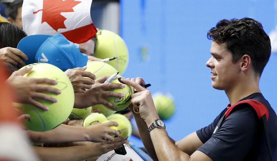 Canada&#39;s Milos Raonic signs autographs after defeating Spain&#39;s Roberto Bautista Agut in their fourth round match at the Australian Open tennis championships in Melbourne, Australia, Monday, Jan. 23, 2017. (AP Photo/Dita Alangkara)