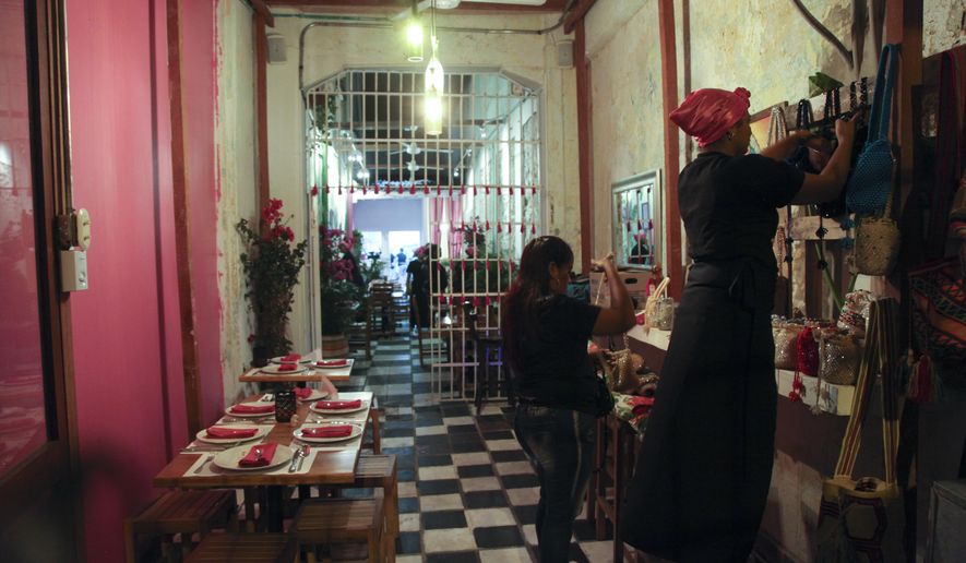 In this Jan. 13, 2017 photo, inmates work in the dining room of the Interno restaurant at the San Diego prison, in Cartagena, Colombia. Convicts have been serving up gourmet meals at the Interno in the all-women prison since December, in a novel experiment intended to promote the inmates’ rehabilitation and confront the Colombian public’s neglect of the country’s exploding prison population. (AP Photo/Alba Tobella)