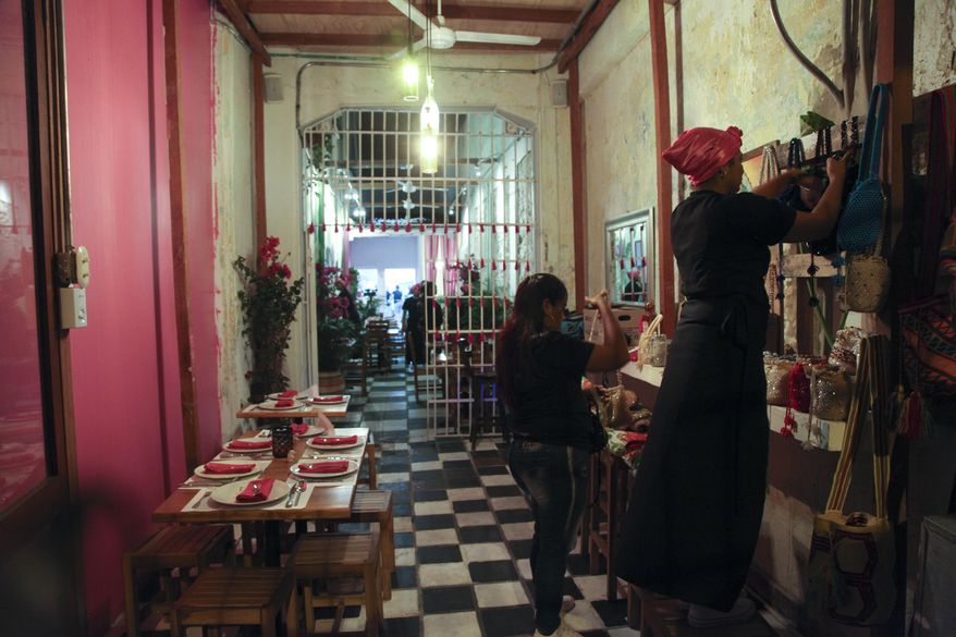 In this Jan. 13, 2017 photo, inmates work in the dining room of the Interno restaurant at the San Diego prison, in Cartagena, Colombia. Convicts have been serving up gourmet meals at the Interno in the all-women prison since December, in a novel experiment intended to promote the inmates’ rehabilitation and confront the Colombian public’s neglect of the country’s exploding prison population. (AP Photo/Alba Tobella)