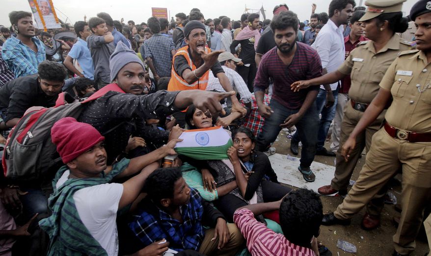 Protestors supporting Jallikattu, a traditional bull-taming ritual try to hold on to each other as police try to remove them from the Marina beach on the Bay of Bengal coast in Chennai, India, Monday, Jan.23, 2017. Protestors attacked a police station with stones and set some vehicles on fire Monday in anger at being forcibly evicted from the beach where they been protesting for the past week in support of the sport. Jallikattu involves releasing a bull into a crowd of people who attempt to grab it and ride it. It is popular in Tamil Nadu state, but India&#39;s top court banned it in 2014 on grounds of animal cruelty. (AP Photo)