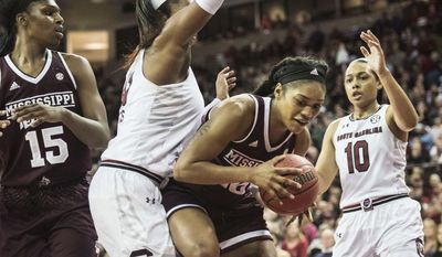 Mississippi State forward Victoria Vivians, second from right, with teammate Teaira McCowan (15), drives to the hoop against South Carolina center Alaina Coates, second from left, and Allisha Gray (10) during the first half of an NCAA college basketball game, Monday, Jan. 23, 2017, in Columbia, S.C. (AP Photo/Sean Rayford)