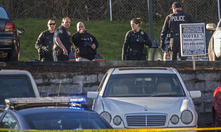 Milton, Wash., police officers investigate the scene of a shooting in the parking lot of an apartment in Minton, Wash., Monday, Jan. 23, 2017. Authorities say two people are dead after a man shot a woman and an officer shot that man south of Seattle. (Peter Haley/The News Tribune via AP)
