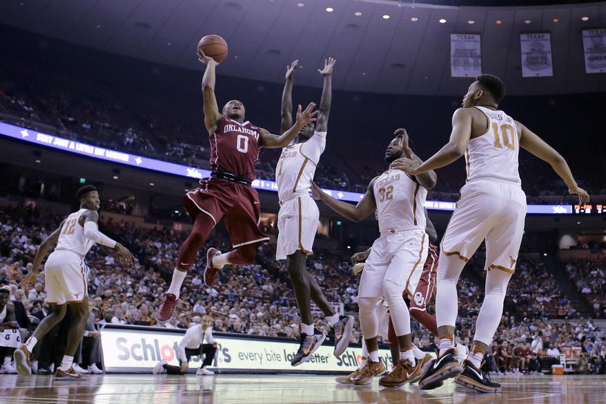 Oklahoma guard Darrion Strong-Moore (0) shoots past Texas guard Andrew Jones (1) during the first half of an NCAA college basketball game, Monday, Jan. 23, 2017, in Austin, Texas. (AP Photo/Eric Gay)