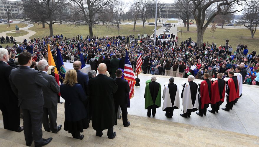 State Representatives and Senators stand with organizers of a protest against Roe v. Wade on the steps of the Statehouse in Topeka, Kan., as hundreds converged on the Kansas Statehouse to mark the 1973 Supreme Court decision that legalized abortion nationwide,Monday, Jan. 23, 2017. Abortion opponents expressed optimism Monday that Donald Trump's early months in office would advance their cause. (AP Photo/Orlin Wagner)
