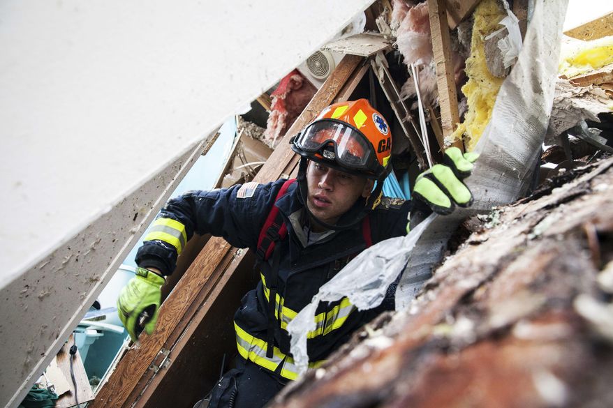 A rescue worker searches inside a mobile home Monday, Jan. 23, 2017, in Big Pine Estates that was damaged by a tornado, in Albany, Ga. Fire and rescue crews were searching through the debris Monday, looking for people who might have become trapped when the storm came through. (AP Photo/Branden Camp)