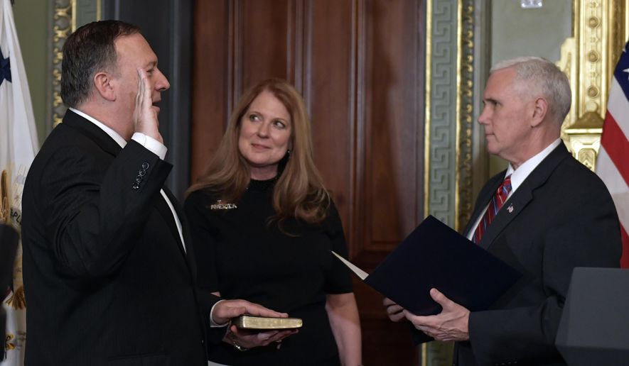 Vice President Mike Pence, right, swears in CIA Director Mike Pompeo, left, as Pompeo&#x27;s wife Susan, center, watches in the Vice President&#x27;s Ceremonial Office in the Eisenhower Executive Office Building in the White House complex in Washington, Monday, Jan. 23, 2017. (AP Photo/Susan Walsh)