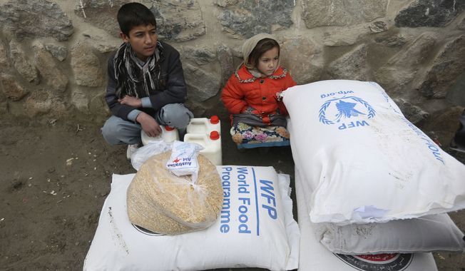 Children wait for transportation after receiving food donated by the World Food Program, in Kabul, Afghanistan, Tuesday, Jan. 24, 2017. (AP Photo/Rahmat Gul)