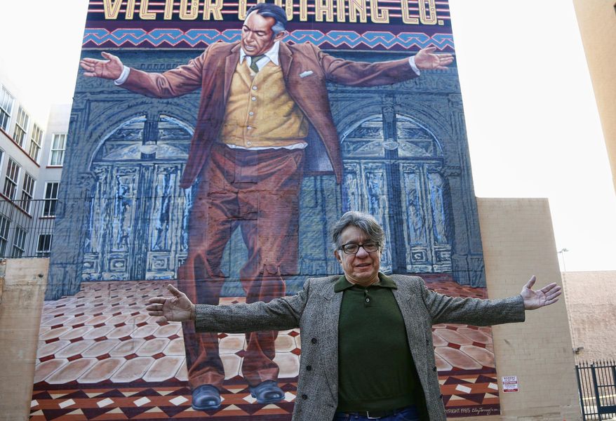 Muralist Eloy Torrez poses for a photo in front of his renovated 70-foot-tall mural of Oscar-winning actor Anthony Quinn, titled "Pope of Broadway," downtown Los Angeles on Tuesday, Jan. 24, 2017. The prominent Chicano artist was among some 100 people to gather Tuesday under the work he spent nearly four months restoring last year. Torrez first put Quinn on a wall of downtown's venerable Victor Clothing Company building in 1985. City officials, actor Edward James Olmos, members of Quinn's family and others spent seven years raising funds and cutting through red tape to get Torrez the ok to repair it.(AP Photo/Nick Ut)
