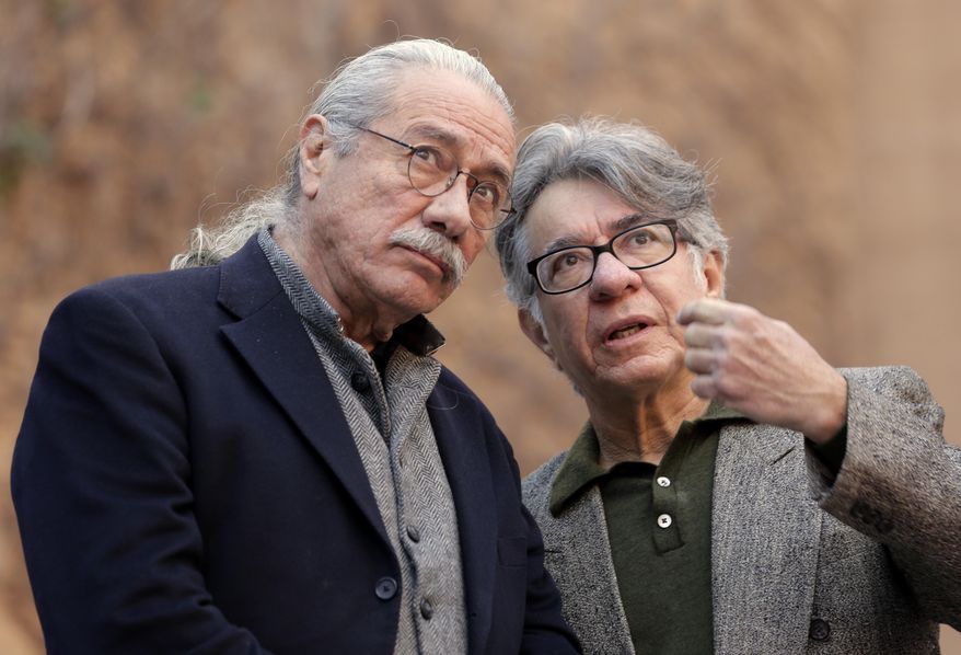 Actor Edward James Olmos, left, and muralist Eloy Torrez look up at Torrez's renovated 70-foot-tall mural of Oscar-winning actor Anthony Quinn, titled "Pope of Broadway," downtown Los Angeles. The prominent Chicano artist was among some 100 people to gather Tuesday, Jan. 24, 2017, under the work he spent nearly four months restoring last year. City officials, Olmos, members of Quinn's family and others spent seven years raising funds and cutting through red tape to get Torrez the OK to repair it. (AP Photo/Nick Ut)