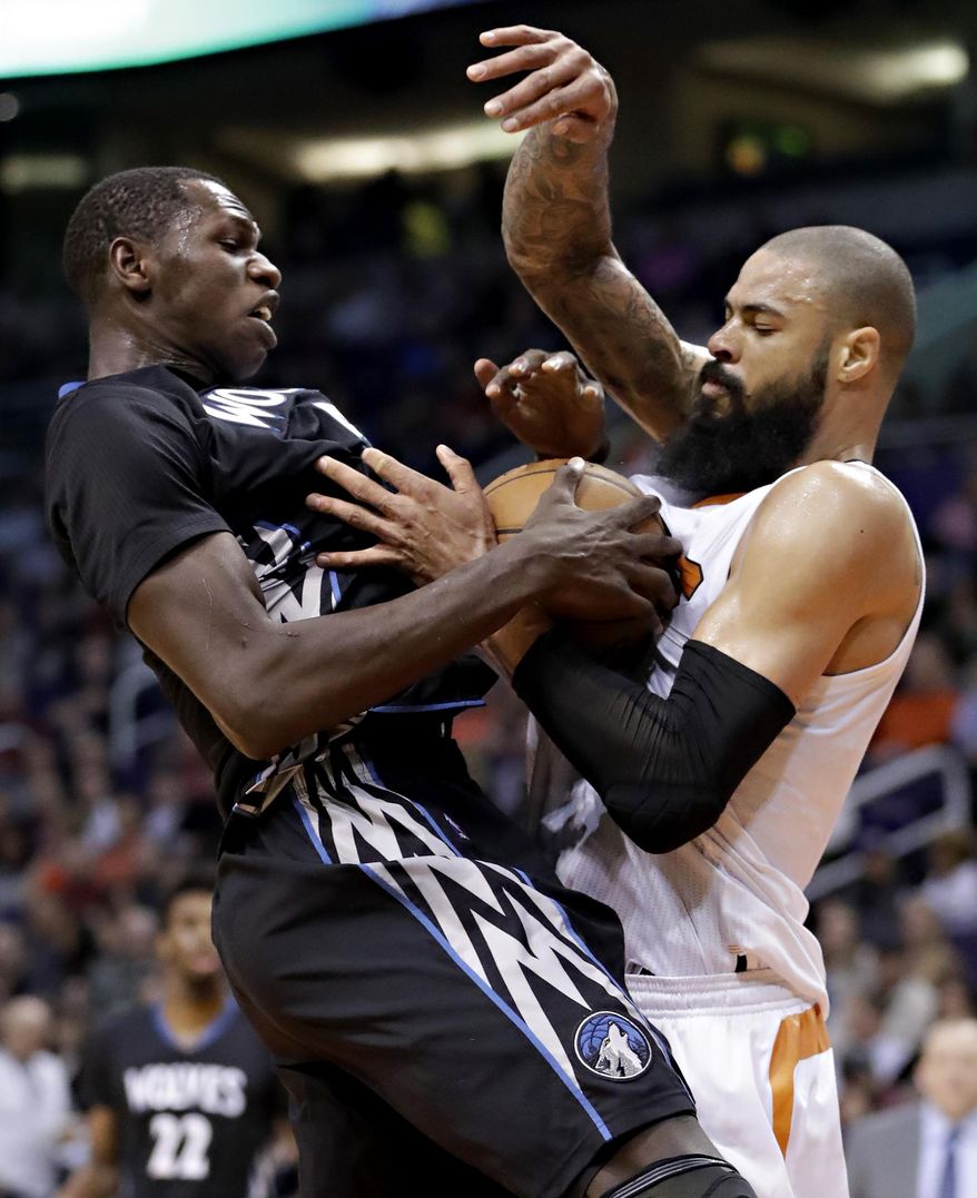 Minnesota Timberwolves forward Gorgui Dieng, left, and Phoenix Suns center Tyson Chandler, right, battle for possession during the first half of an NBA basketball game, Tuesday, Jan. 24, 2017, in Phoenix. (AP Photo/Matt York)