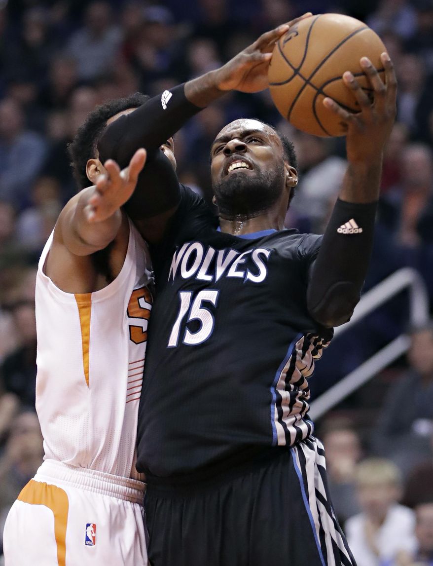 Minnesota Timberwolves forward Shabazz Muhammad (15) drives past Phoenix Suns forward TJ Warren during the first half of an NBA basketball game, Tuesday, Jan. 24, 2017, in Phoenix. (AP Photo/Matt York)