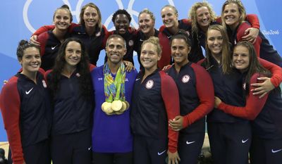 FILE - In this Aug. 19, 2016, file photo, members of United States women water polo team pose with a coach Adam Krikorian during the medals ceremony at the 2016 Summer Olympics in Rio de Janeiro, Brazil. U.S. water polo coaches Adam Krikorian and Dejan Udovicic are staying on for the 2020 Tokyo Olympics. (AP Photo/Sergei Grits, File)