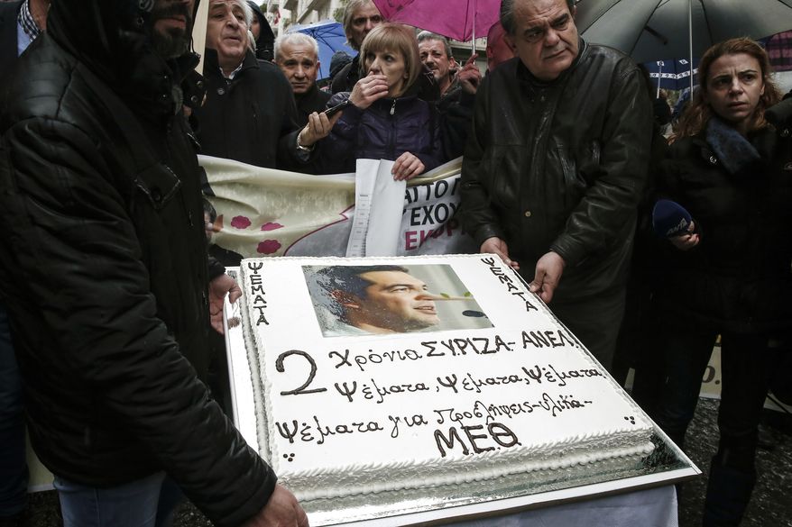 Protesters carry a birthday cake depicting Greek Prime Minister Alexis Tsipras with a Pinocchio nose during a protest against government's policies on health issues in Athens, Wednesday, January 25, 2017. Greece's left-wing government says it is willing to extend an automatic austerity mechanism for one additional year in an effort to break the deadlock on current bailout negotiations. On the cake reads : "Two years of SYRIZA -ANEL, Lies, lies, about hirings and medical supplies for intensive care units." (AP Photo/Yorgos Karahalis)