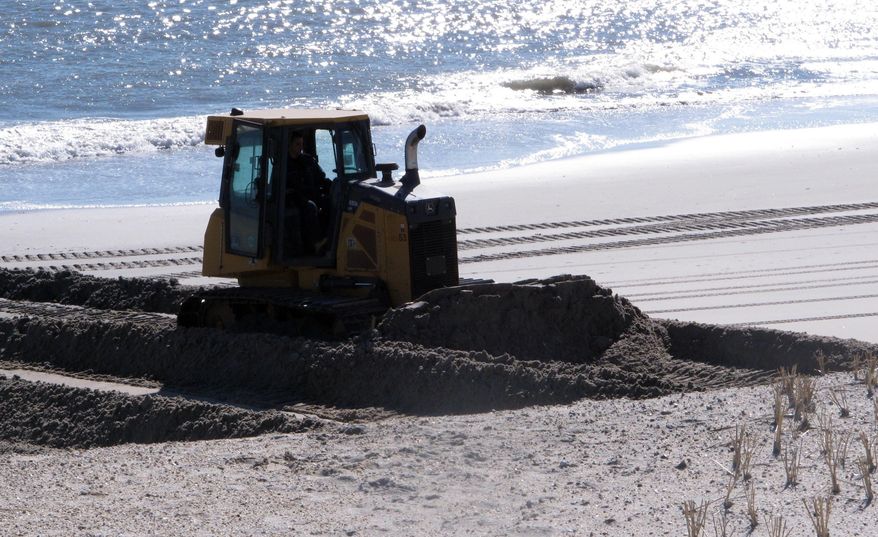 A bulldozer pushes sand back onto a badly eroded beach in the Holgate section of Long Beach Township N.J. on Wednesday, Jan. 25, 2017, after a two-day nor'easter caused moderate to significant beach erosion along the Jersey shore. (AP Photo/Wayne Parry)