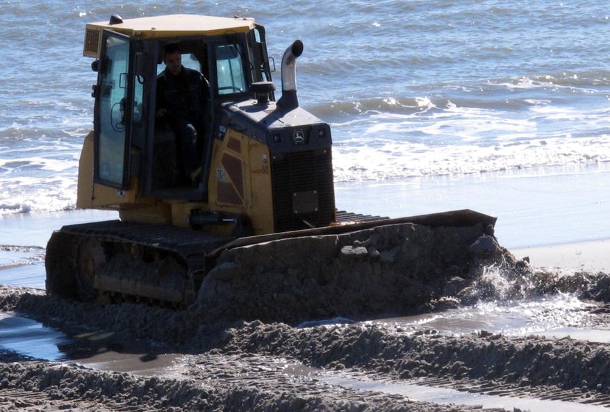 A bulldozer pushes sand back onto a badly eroded beach in the Holgate section of Long Beach Township N.J. on Tuesday Jan. 25, 2017 after a two-day nor'easter that caused moderate to significant beach erosion along the Jersey shore. Some of the hardest-hit places were those that suffered great damage in Superstorm Sandy in 2012, and are still waiting for a protective sand dune project to be built, but resistance from some homeowners has thus far delayed the work in places. (AP Photo/Wayne Parry)