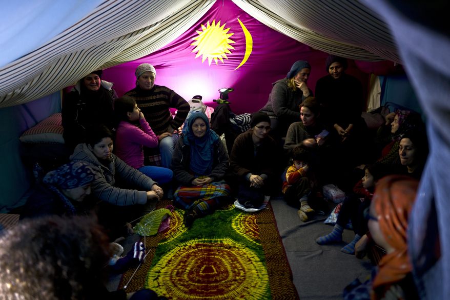 In this Wednesday, Jan. 18, 2017 photo, Syrian refugee women attend a knitting class part of emotional support session provided to them by volunteers from the Refugee Trauma Initiative, in a tent in Frakapor refugee camp on the outskirts of the northern Greek city of Thessaloniki. Many migrants living in this warehouse tent camp and another one nearby are feeling burned out. They try to keep busy as they dream of a better life in Western Europe and not let boredom or depression set in. (AP Photo/Muhammed Muheisen)