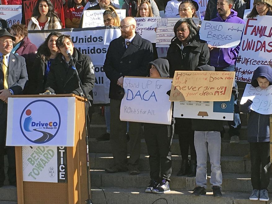 Mateo Lozano, left, at podium, who arrived illegally in the U.S., as a child from Colombia, speaks at a rally at the Colorado state Capitol, Wednesday, Jan. 23, 2017, in Denver. Lozano and others called for an expansion of a state program that allows those living here illegally to get driver's licenses. (AP Photo/Jim Anderson)