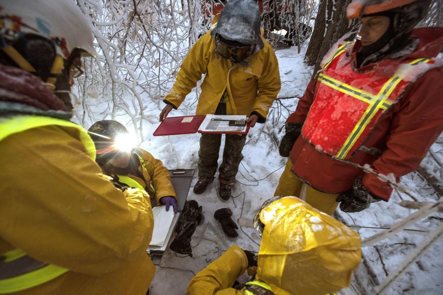 In this Jan. 19, 2016 photo provided by Hubbard Brook Research Foundation, researchers gather to measure ice accumulation on wooden collectors in the Hubbard Brook Experimental Forest in Woodstock, N.H. Scientists have been creating ice storms there to help understand the effects of ice on northern forests. (Joe Klementovich/Hubbard Brook Research Foundation via AP)