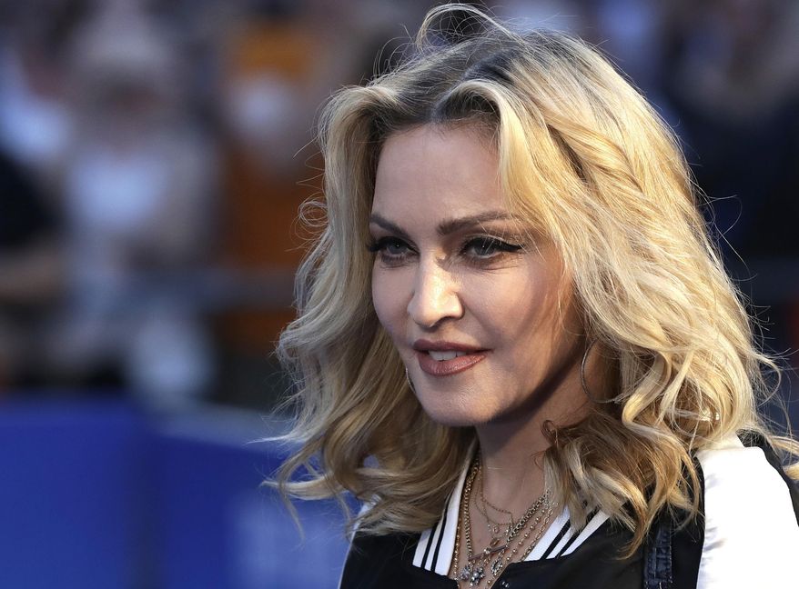 FILE- In this Sept. 15, 2016, file photo, musician Madonna poses for photographers upon arrival at the World premiere of the film "The Beatles, Eight Days a Week" in London. Pop star Madonna has filed for the adoption of two more children from Malawi. A government spokesman said the singer appeared before a High Court judge on Wednesday, Jan. 25, 2017. (AP Photo/Kirsty Wigglesworth, File)