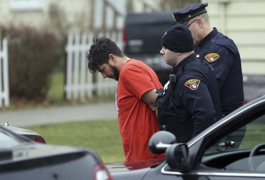 This Tuesday, Jan. 24, 2017 photo shows Cleveland police officers taking Israel Alvarez into custody in Lorain, Ohio. Alvarez has been charged with aggravated vehicular homicide and felony hit-skip in the death Tuesday morning of 39-year-old Patrolman David Fahey. (Joshua Gunter/Cleveland.com via AP)