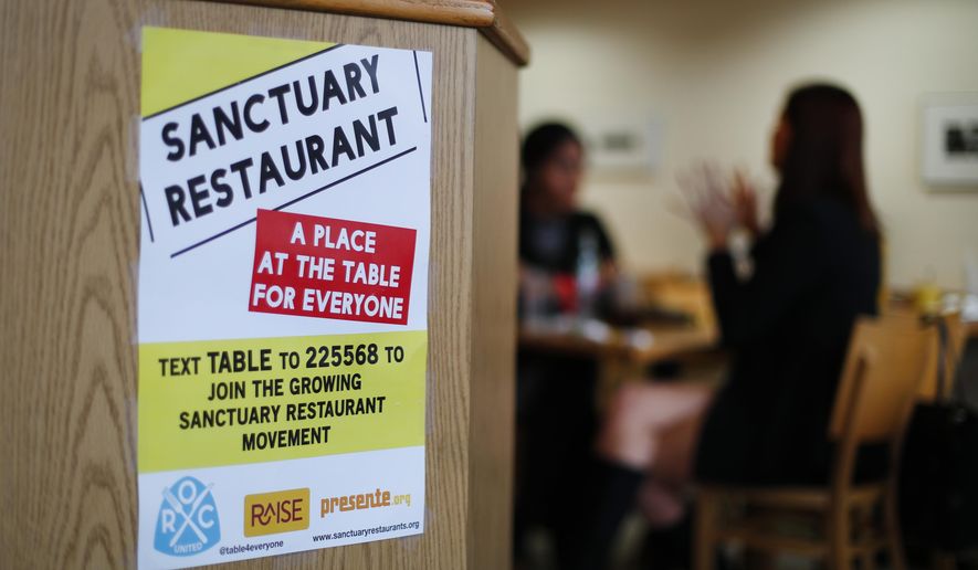 In this Wednesday, Jan. 18, 2017 photo, a sanctuary restaurant sign is shown at Russell Street Deli in Detroit. Dozens of restaurants are seeking “sanctuary” status, a designation owners hope will help protect employees in an immigrant-heavy industry and tone down fiery rhetoric sparked by the presidential campaign. (AP Photo/Paul Sancya)