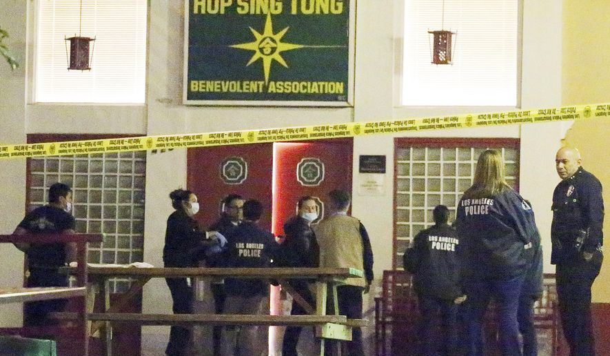 Los Angeles police detectives investigate the area where two men were stabbed to death in the city's Chinatown district Thursday, Jan. 26, 2017. Police say a man in his 30s entered the Hop Sing Tong Benevolent Association club Thursday afternoon, and got into an argument with one victim, pulled a knife and stabbed him several times. Officer Tony Im says another man tried to intervene and also was stabbed. (AP Photo/Reed Saxon)
