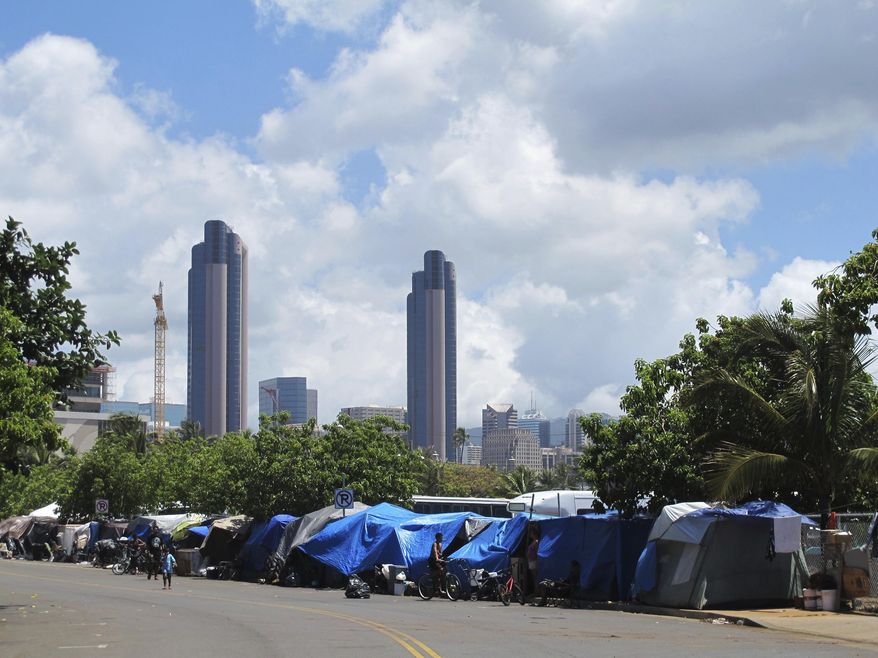 FILE - In this June 30, 2015, file photo, people camp out on a sidewalk in the Kakaako neighborhood of Honolulu. A Hawaii lawmaker wants to classify homelessness as a medical condition so that people could use Medicaid money for rent payments. As a doctor, Sen. Josh Green argues that he's constantly treating homeless people in the emergency room where he works. (AP Photo/Audrey McAvoy, File)