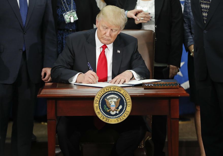 In this Jan. 25, 2017, photo, President Donald Trump signs an executive order for border security and immigration enforcement improvements at the Department of Homeland Security in Washington. Immigration to the United States has come in swells and dips over the past two-plus centuries, driven by shifts in U.S. policy, the mood in the country and world events. (AP Photo/Pablo Martinez Monsivais)