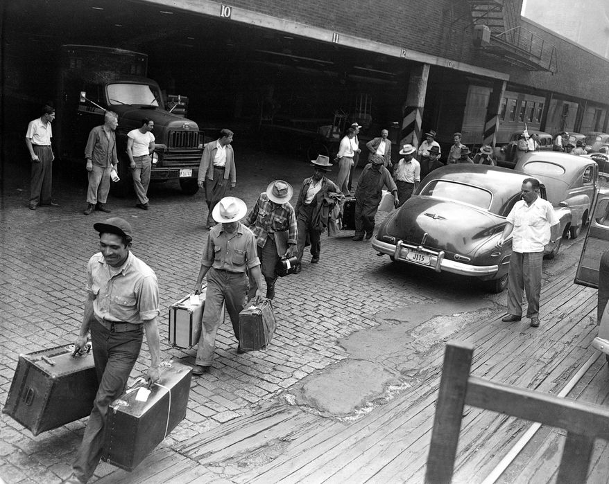 FILE - In this 1951 file photo, deported migrant farm workers carrying their belongings at a train station in Chicago. Immigration to the U.S. has come in swells and dips over the past two-plus centuries, driven by shifts in U.S. policy, the mood in the country and world events.Labor shortages, racial tension, economic forces, religious prejudice and national security concerns all fit into the picture. (AP Photo/File)