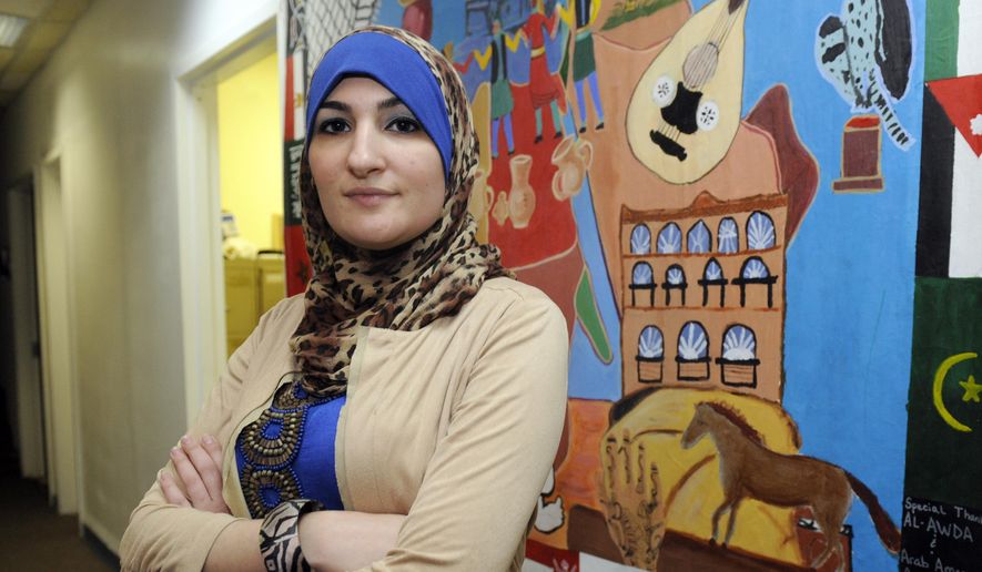In this Dec. 29, 2011, file photo, Linda Sarsour, executive director of the Arab American Association of New York, poses for photos in front of a canvas painted by the association&#39;s youth group at its headquarters in the Brooklyn borough of New York. (AP Photo/Henny Ray Abrams, File)