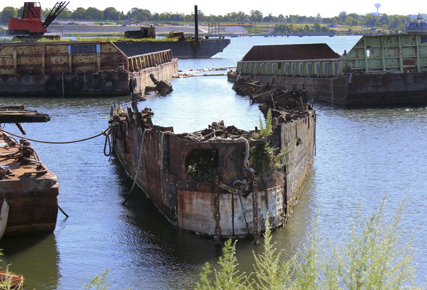FILE - In this Aug. 22, 2016 file photo, rusting remnants of an old Russian submarine, used as a set for a Harrison Ford movie and as a floating museum until sinking during a 2007 nor'easter, sits rusting in a scrapyard in the Providence River in Providence, R.I. State environmental officials sued to have the sub and several other vessels removed from the river. A state superior court judge ordered Rhode Island Recycled Metals LLC in December to begin removing the vessels from the river. The permitting process is underway. (AP Photo/Jennifer McDermott, File)