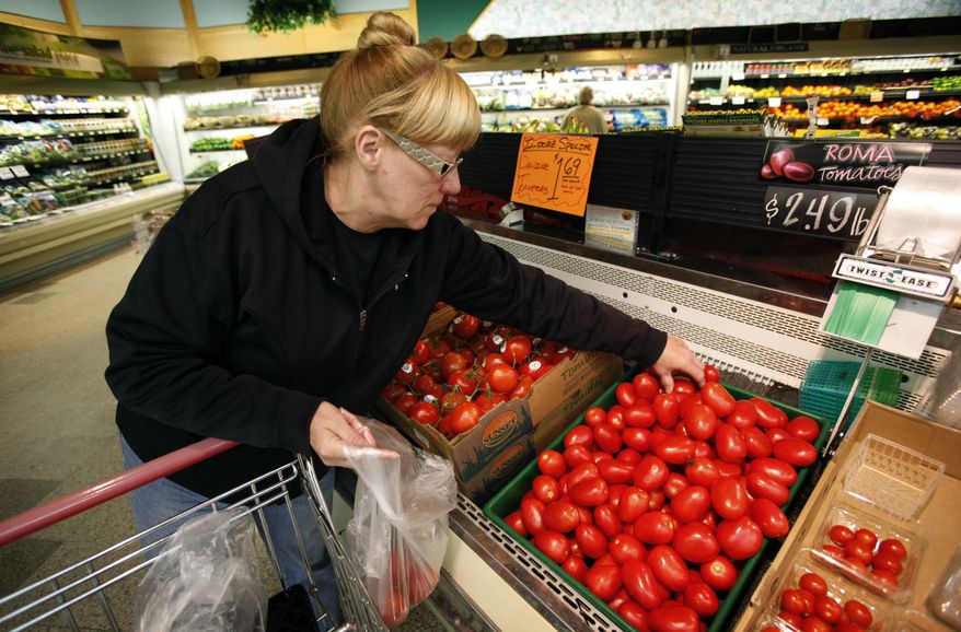 FILE - In this March 23, 2011 file photo, a woman shops for tomatoes at a grocery store in Des Moines, Iowa. Scientists have cooked up a way to reintroduce a key ingredient into mass-produced tomatoes: taste. Researchers have figured out just the right spots on the genetic blueprint of tomatoes where flavor has been bred out of supermarket tomatoes for the past 40 or 50 years, according to a study in the journal Science. And using natural breeding methods, a little modernized with hand pollination by electric toothbrushes _ they are reinstalling five factors to add aroma and taste into the staple of salads. (AP Photo/Charlie Neibergall, File)