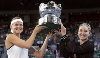 Bethanie Mattek-Sands, right, of the U.S. and Lucie Safarova of the Czech Republic hold their trophy aloft after defeating Andrea Hlavackova of the Czech Republic and Peng Shuai of China in the women&#39;s doubles final at the Australian Open tennis championships in Melbourne, Australia, Friday, Jan. 27, 2017. (AP Photo/Aaron Favila)