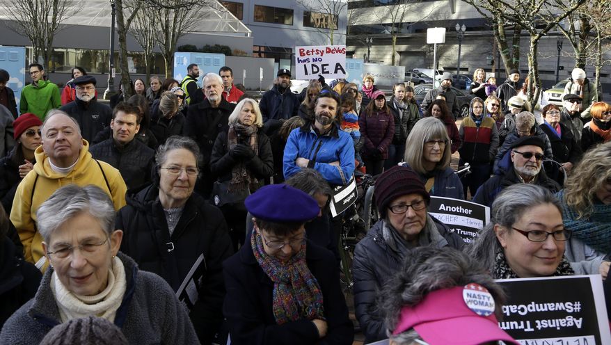 People listen to speakers during a rally in Portland, Ore., Friday, Jan. 27, 2017. Several hundred people gathered with Oregon congressional leaders in protest against Education Secretary nominee Betsy DeVos. (AP Photo/Don Ryan)