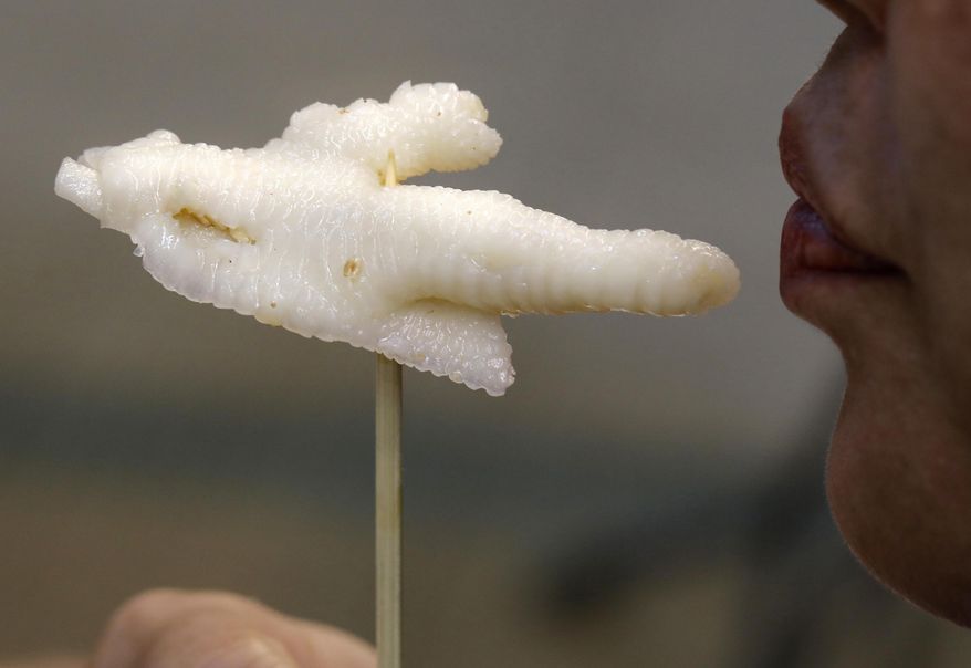 In this Monday, Jan. 23, 2017 photo, chicken feet snacks shop owner Leung Kin-kung testes a chicken feet in Hong Kong. Saturday marks the start of the lunar Year of the Rooster and families in China will reunite for festivities, fireworks and food. While tradition calls for feasting on “auspicious” foods, many will also munch on staple snacks like “phoenix claws,” the Chinese name for chicken feet. (AP Photo/Vincent Yu)
