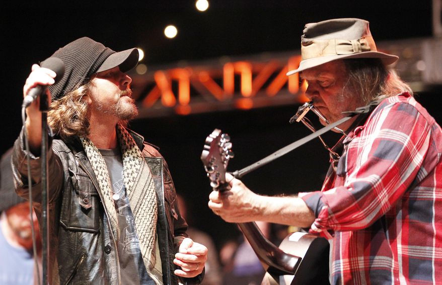FILE - In this Oct. 24, 2010, file photo, Eddie Vedder, left of Pearl Jam performs with Neil Young, right, during the Bridge School Benefit concert in Mountain View, Calif. The Rock & Roll Hall of Fame announced Jan. 27, 2017, that Young will induct Pearl Jam into the Hall on April 7, 2017. (AP Photo/Tony Avelar, File)