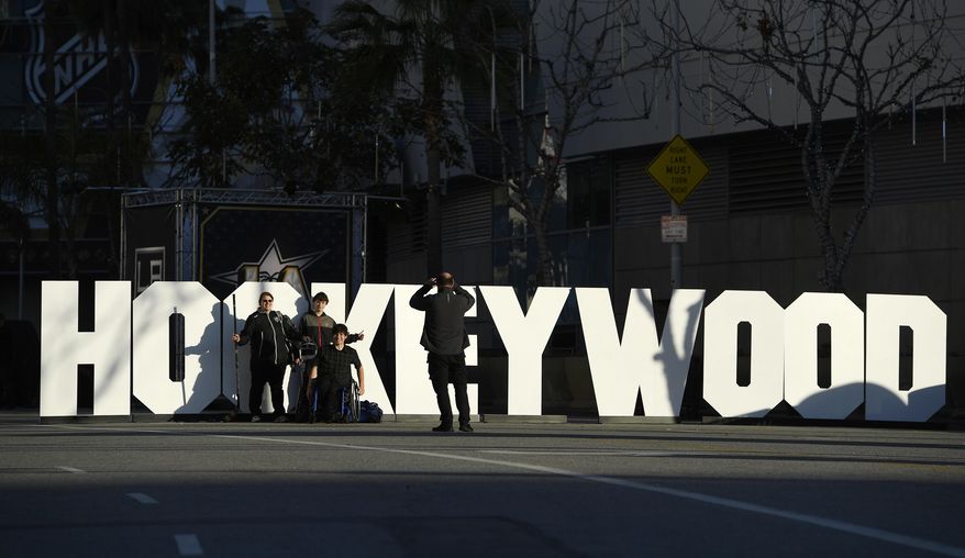 Fans pose in front of a "Hockeywood" sign at Staples Center, Friday, Jan. 27, 2017, in Los Angeles, where the NHL All-Star game will be held Sunday. (AP Photo/Mark J. Terrill)