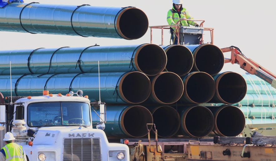 In this May 9, 2015, file photo, workers unload pipes for the proposed Dakota Access oil pipeline that would stretch from the Bakken oil fields in North Dakota to Illinois. The Dakota Access project, which is mostly completed, has created about 12,000 construction jobs, according to project leader Energy Transfer Partners LP. Most of those jobs are over, however. (AP Photo/Nati Harnik, File)