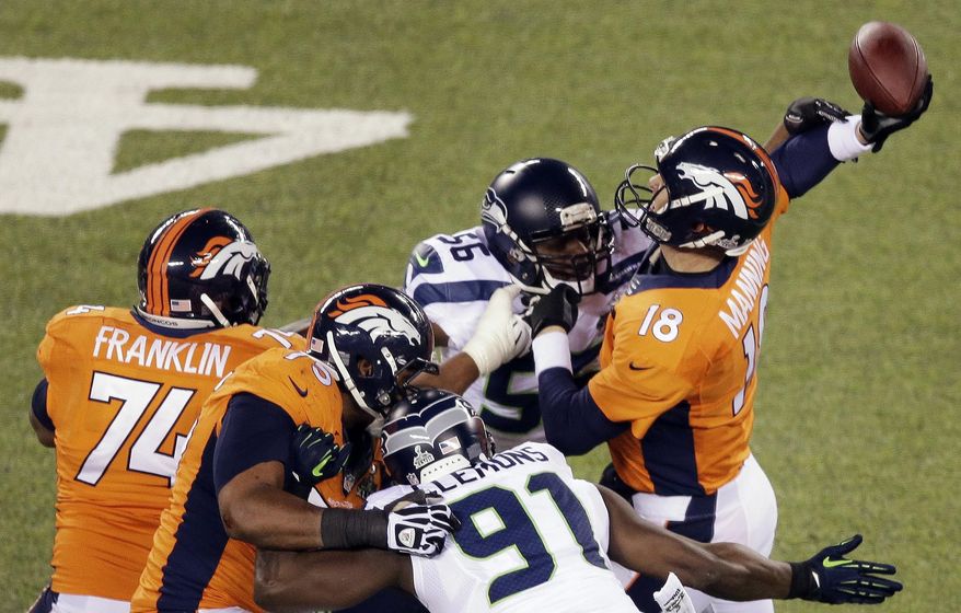 FILE - In this Feb. 2, 2014, file photo, Denver Broncos' Peyton Manning is hit by Seattle Seahawks' Cliff Avril (56) during the first half of the NFL Super Bowl 48 football game in East Rutherford, N.J. Seattle defeated Denver 43-8. The top "D" almost always prevails against the top "O," going 5-1 so far when those teams meet to determine a champion _ even though each offense was led by a quarterback who is in the Pro Football Hall of Fame (or, in the most recent case, is expected to be). (AP Photo/Charlie Riedel, File)