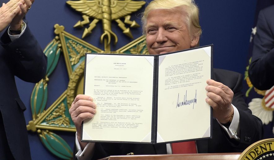 President Donald Trump shows his signature on an executive action on rebuilding the military during an event at the Pentagon in Washington, Friday, Jan. 27, 2017. (AP Photo/Susan Walsh)