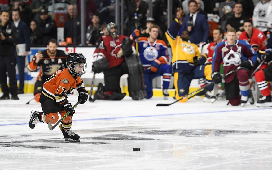 Ryker Kesler, left, son of Anaheim Ducks' Ryan Kesler, right, gets ready to shoot on Montreal Canadiens goalie Carey Price as members of the All-Star team cheer him on during the Shootout portion of the NHL All-Star Skills Competition, Saturday, Jan. 28, 2017, in Los Angeles. (AP Photo/Mark J. Terrill)