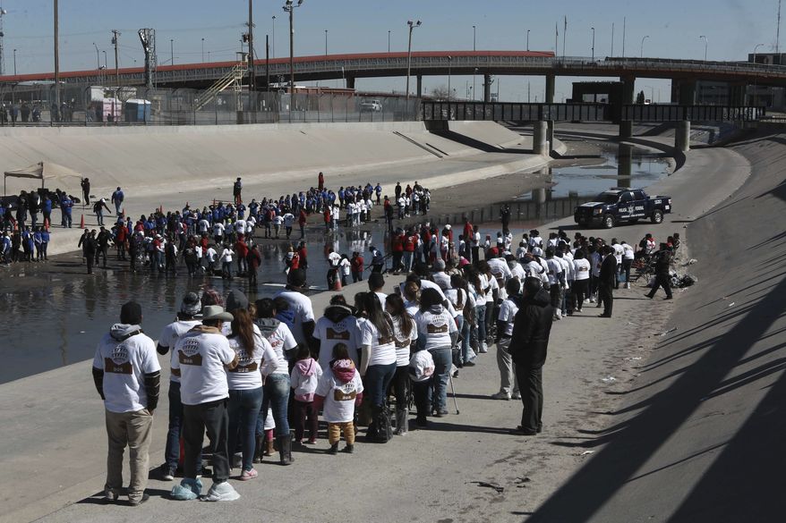 Hundreds of persons line up meet friends and relatives on the U.S. - Mexico border on the Rio Grande in Ciudad Juarez, Mexico, Saturday, Jan 28, 2017. Hundreds of people from Ciudad Juarez gathered along the U.S.-Mexico border to reunite with relatives from El Paso, Texas, for a few precious minutes. (AP Photo/Christian Torres)