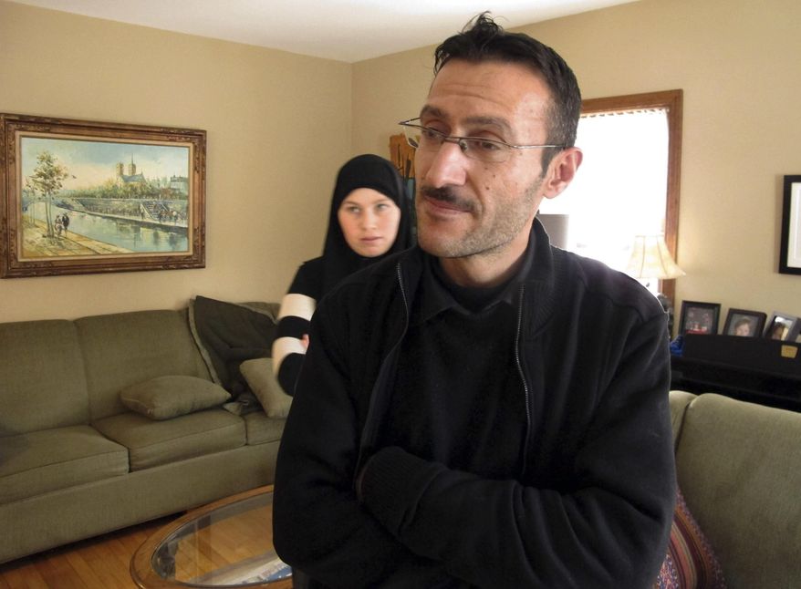 Syrian refugee Ahmed Khatib and his wife Mahasen Boshnaq, rear, stand in the home of their sponsoring family Friday, Jan. 27, 2017, in Rutland, Vt. After studying agricultural technology in college, Khatib said he hopes to finish his degree in the U.S. (AP Photo/Lisa Rathke)