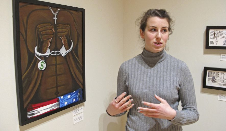 Amy Chalmers, program assistant at Ohio State University's Billy Ireland Cartoon Library & Museum, discusses the exhibit "Windows on Death Row: Art from Inside and Outside the Prison Walls" on Wednesday, Jan. 25, 2017, at the museum in Columbus, Ohio. The exhibit, touring internationally, combines political cartoons about capital punishment with art by death row inmates from Arkansas, California, North Carolina, Tennessee and Texas, some who have since been executed. Scheduled to be on view at the museum from Nov. 5, 2016, through March 12, 2017, the exhibit opened in Los Angeles on Oct. 22, 2015, before visiting Chapel Hill, N.C., Switzerland and Norway. (AP Photo/Andrew Welsh-Huggins)