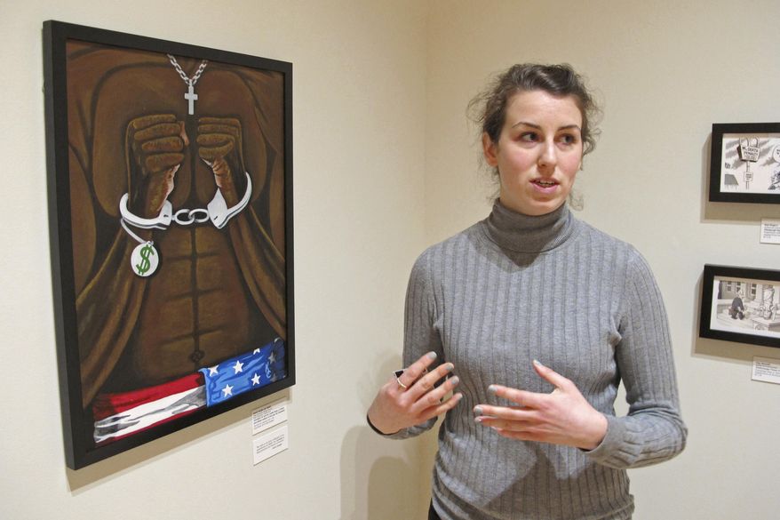 Amy Chalmers, program assistant at Ohio State University's Billy Ireland Cartoon Library & Museum, discusses the exhibit "Windows on Death Row: Art from Inside and Outside the Prison Walls" on Wednesday, Jan. 25, 2017, at the museum in Columbus, Ohio. The exhibit, touring internationally, combines political cartoons about capital punishment with art by death row inmates from Arkansas, California, North Carolina, Tennessee and Texas, some who have since been executed. Scheduled to be on view at the museum from Nov. 5, 2016, through March 12, 2017, the exhibit opened in Los Angeles on Oct. 22, 2015, before visiting Chapel Hill, N.C., Switzerland and Norway. (AP Photo/Andrew Welsh-Huggins)