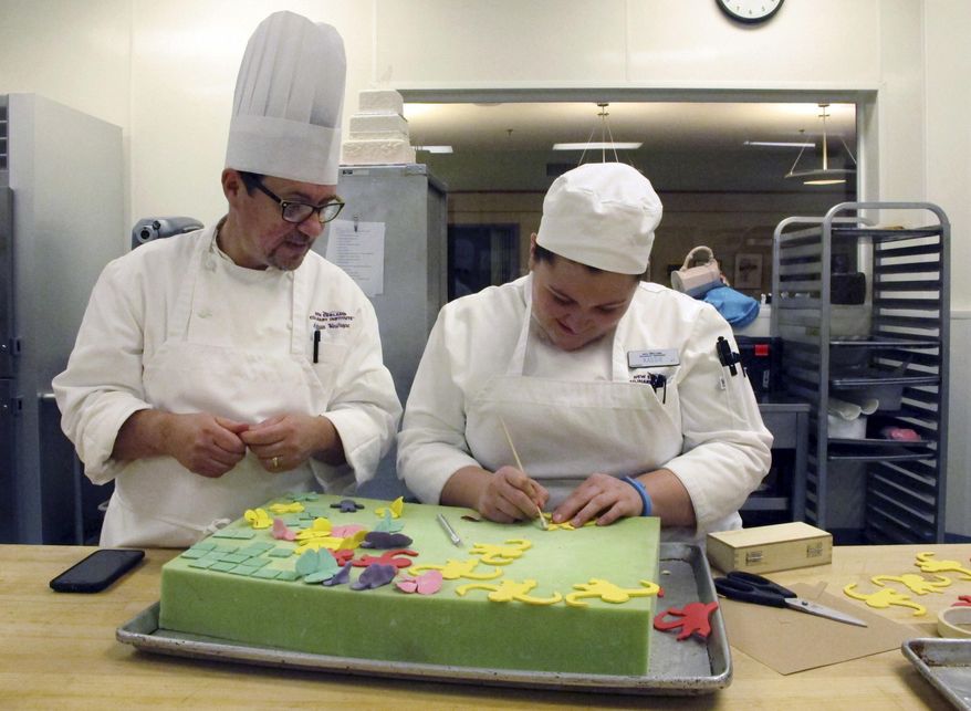 In this Jan. 26, 2017 photo, New England Culinary Institute instructor Chef Adrian Westrope, left, discusses a dessert project with student Kassie Jardine in Montpelier, Vt. Enrollment in culinary institutes across the country is in decline and some cooking schools have announced they are closing. NECI, which faces imminent sale, said it is committed to staying relevant and in demand. (AP Photo/Lisa Rathke)