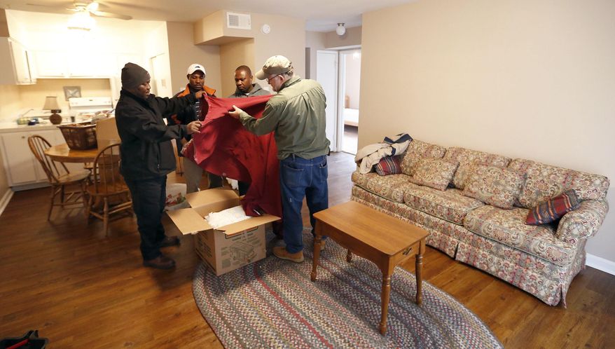 ADVANCE FOR WEEKEND EDITIONS, JAN. 28-29 - In this Wednesday, Jan. 18, 2017 photo, from left, David Balondani, Asukulu Ramadhani, Raphael Ngalula, Reid Buchanan, help prepare an apartment in Lexington, Ky. St. Luke United Methodist Church, has "adopted" a Congolese refugee family through Kentucky Refugee Ministries. The team, who all came here through KRM themselves, moved donated furniture into the family's apartment to make it ready for their arrival tonight. St. Luke United Methodist Church hosts a Swahili-speaking service that draws about 115 Congolese each week, and many of them are refugees. (Charles Bertram/Lexington Herald-Leader via AP)