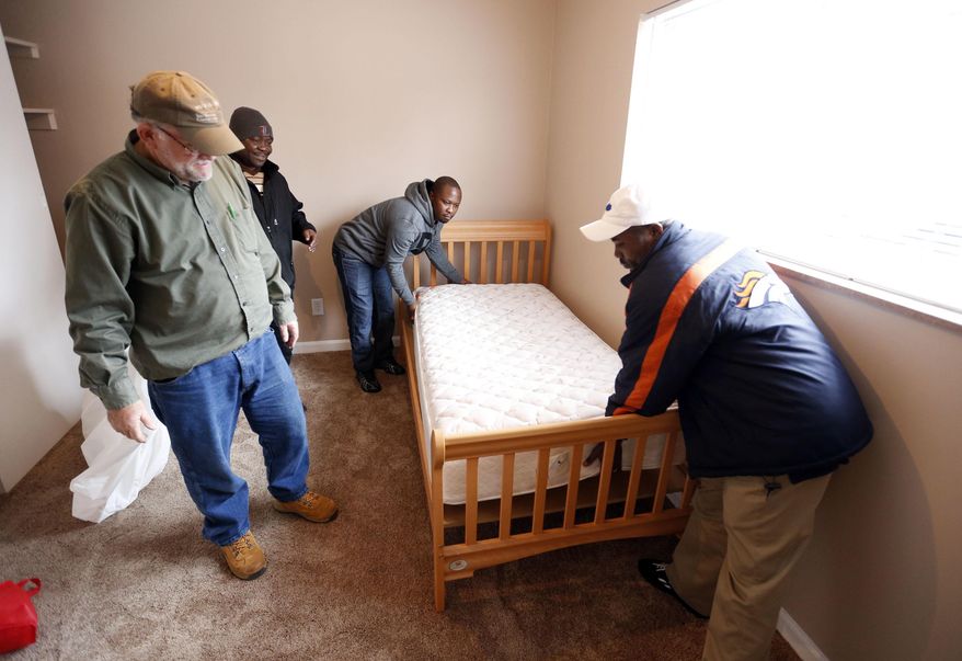 ADVANCE FOR WEEKEND EDITIONS, JAN. 28-29 - In this Wednesday, Jan. 18, 2017 photo, from left, Reid Buchanan, David Balondani, Raphael Ngalula, Asukulu Ramadhani, help prepare an apartment in Lexington, Ky. St. Luke United Methodist Church, has "adopted" a Congolese refugee family through Kentucky Refugee Ministries. The team, who all came here through KRM themselves, moved donated furniture into the family's apartment to make it ready for their arrival tonight. St. Luke United Methodist Church hosts a Swahili-speaking service that draws about 115 Congolese each week, and many of them are refugees. (Charles Bertram/Lexington Herald-Leader via AP)