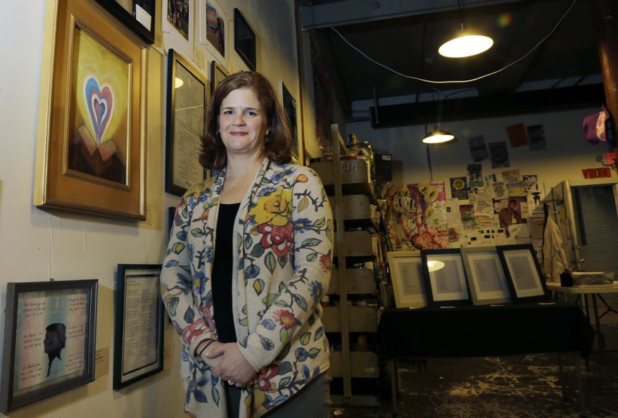 In this Jan. 25, 2017 photo, artist Christy Hegerty poses next to her painting entitled "The Gift," a part of the group exhibit "This is What TRANS Feels Like" at Wrong Brain Art Collective in Dover, N.H. The New Hampshire art exhibit focuses on what it means to be transgender and the experiences transgender men and women face. (AP Photo/Elise Amendola)
